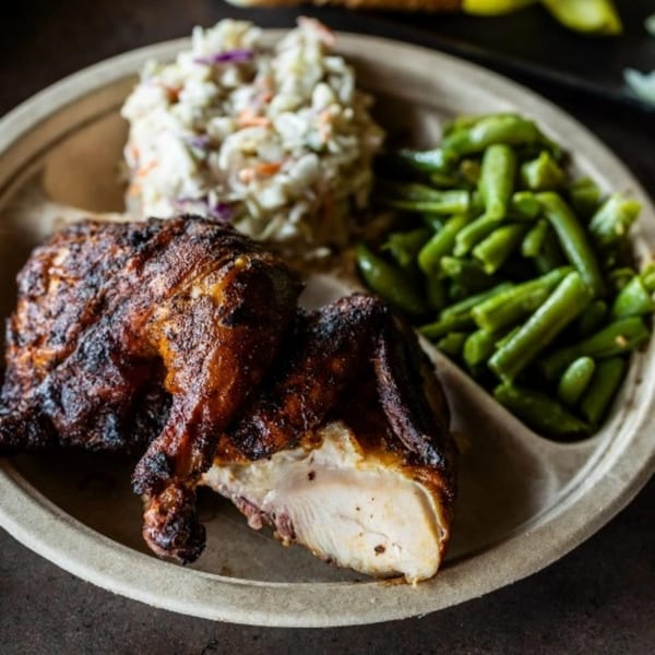 Meyer's Elgin Smokehouse BBQ chicken, coleslaw, and green beans on a divided plate.