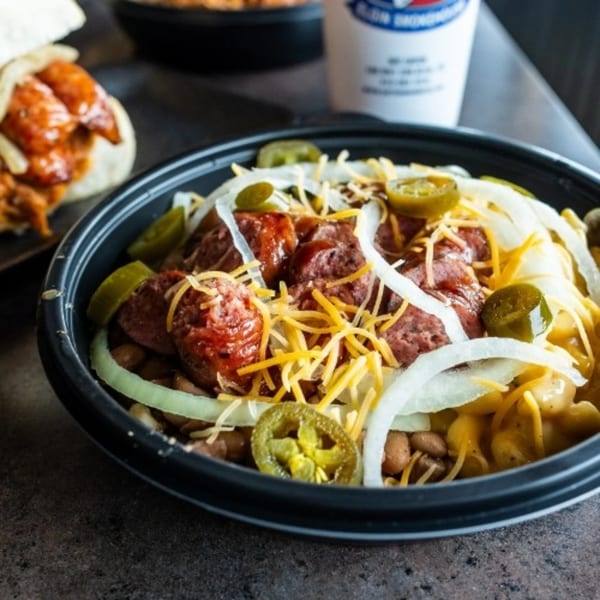 Meyer's Elgin Smokehouse BBQ bowl with sausage, beans, mac and cheese, onions, and jalapeños.