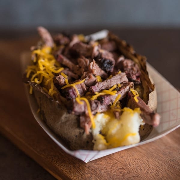 Meyer's Elgin Smokehouse baked potato loaded with shredded brisket and melted cheddar cheese.